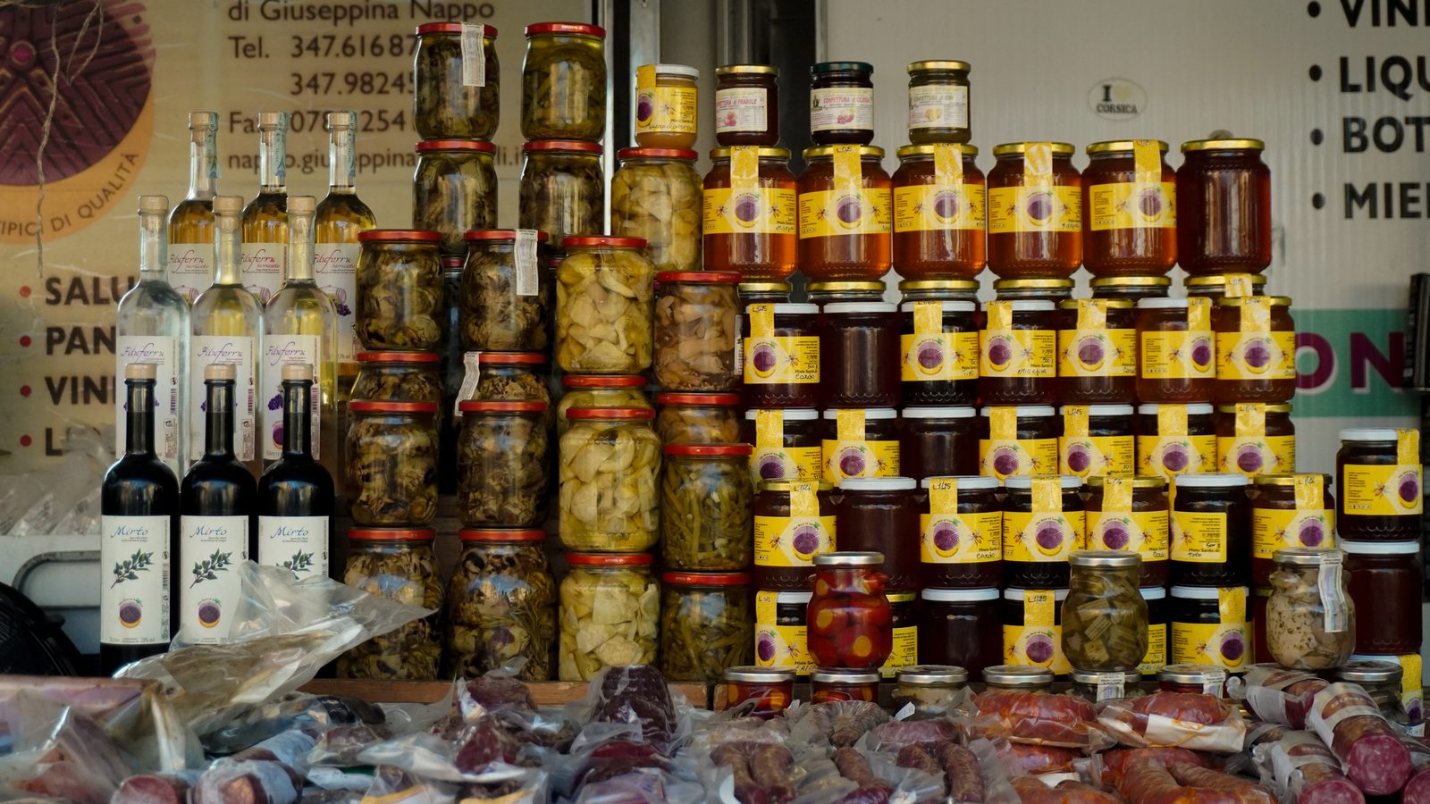 La dispensa sarda: mieli, conserve sott'olio, mirto e fileferru esposti al banco